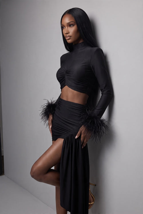 The Saint 54 Miss Rose black long-sleeve crop top featuring elegant ostrich feather cuffs on a model