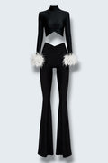 The Saint 54 black fitted polo top with detachable white ostrich feather cuffs and matching high-waisted flared pants.