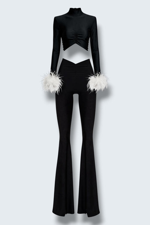 The Saint 54 black fitted polo top with detachable white ostrich feather cuffs and matching high-waisted flared pants.