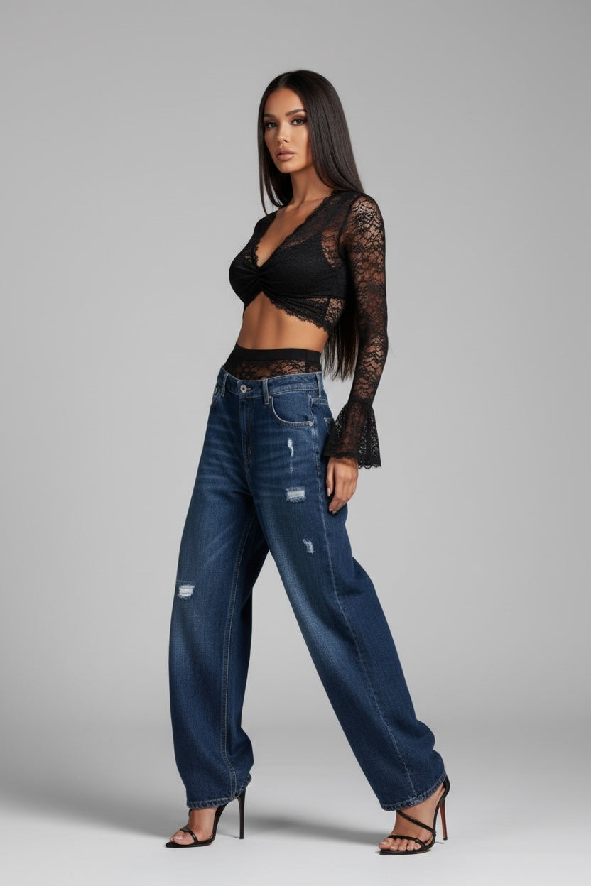 The Saint 54 black lace long-sleeve crop top with V-neck and floral motif worn with distressed blue denim jeans.