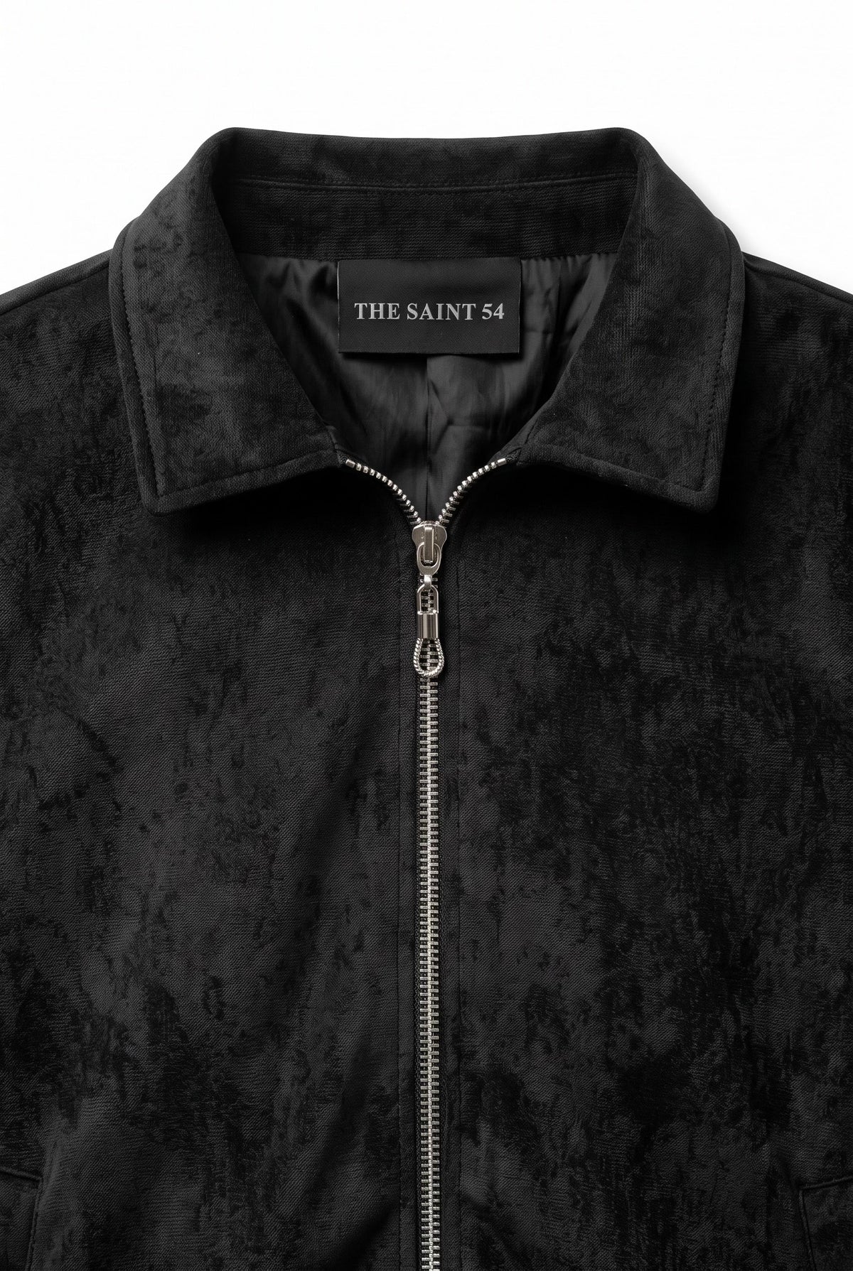 The Saint 54 black suede bomber jacket and ruffled mini skirt set worn by a model against a white background.