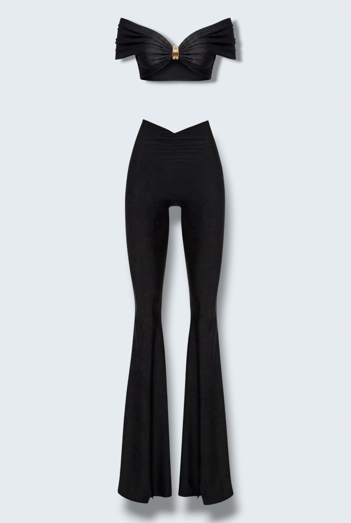 The Saint 54 black two-piece set featuring a cropped off-shoulder top with gold hardware and flared high-waisted pants.