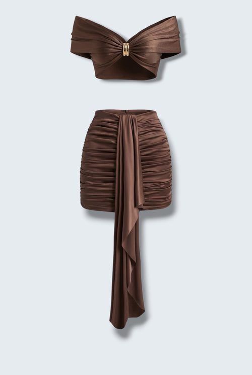 The Saint 54 brown satin two-piece set with a draped off-shoulder crop top and a ruched mini skirt with scarf detail.